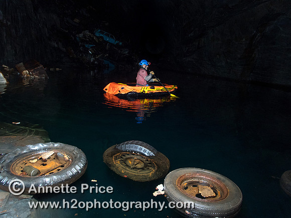 Peter Hamilton paddles past floating wheels towards the car graveyard. Gaewern Slate Mine.