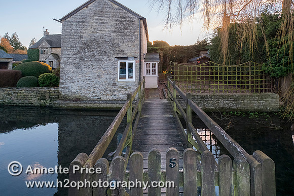 Ashton Keynes.  Most houses on the west side of the High Street have their own bridge over Thames.