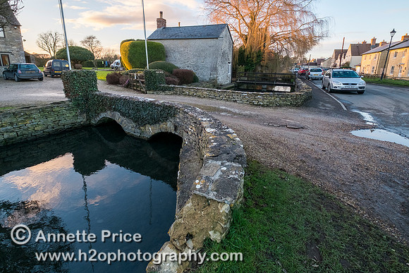 Ashton Keynes.  Most houses on the west side of the High Street have their own bridge over Thames.